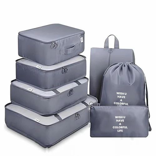 Sieben graue Packwürfel und Reisebeutel für effizientes Kofferpacken.